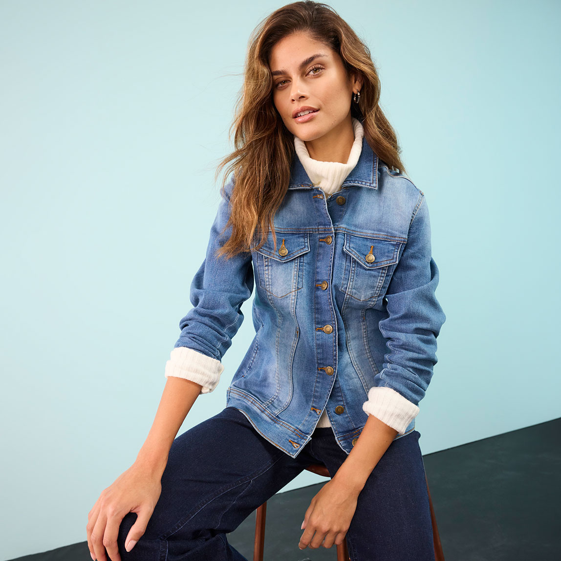 Look aus Jeansjacke, weißem Shirt und dunkler Hose. 